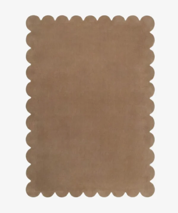 Top down view of the Amber Glint tan colored hand tufted wool rug on a white background showing the rectangular shape and scalloped edges.