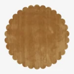 Top down view of the circular Camel Dawn golden tan hand tufted wool rug on a white background showing the scalloped border.