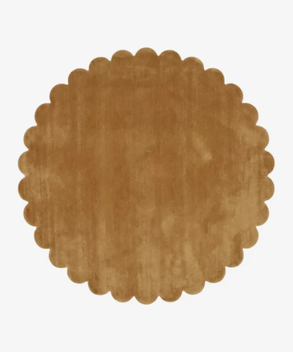 Top down view of the circular Camel Dawn golden tan hand tufted wool rug on a white background showing the scalloped border.