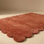 Close up angle showing the plush wool texture and high quality cut pile of the Clay Ember rug edge.