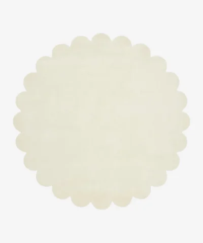 Top down view of the circular Cream Halo off white hand tufted wool rug on a white background showing the soft scalloped border.