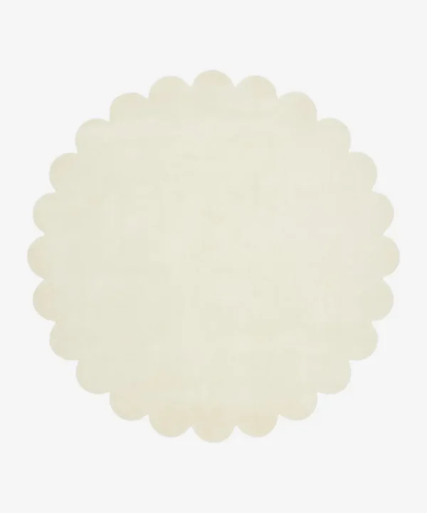 Top down view of the circular Cream Halo off white hand tufted wool rug on a white background showing the soft scalloped border.