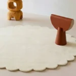 Close up angled perspective of the Cream Halo round rug showing the plush cream wool texture and cut pile.