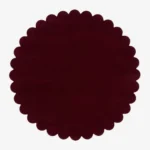 Top down view of the circular Crimson Aura deep red hand tufted wool rug on a white background showing the scalloped border.