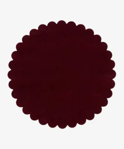 Top down view of the circular Crimson Aura deep red hand tufted wool rug on a white background showing the scalloped border.