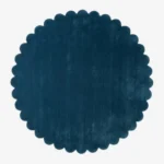 Top down flat lay of the Deepstone round wool rug showing the rich navy blue color and scalloped border.