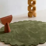 Close up angled perspective of the Forest Mirage round rug showing the plush green wool texture and cut pile.