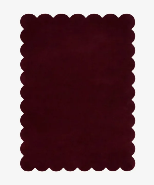 Top down view of the Merlot Plum dark purple hand tufted wool rug on a white background showing the rectangular shape and scalloped edges.