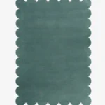 Top down view of the Ocean Mist teal colored hand tufted wool rug on a white background showing the rectangular shape and scalloped edges.