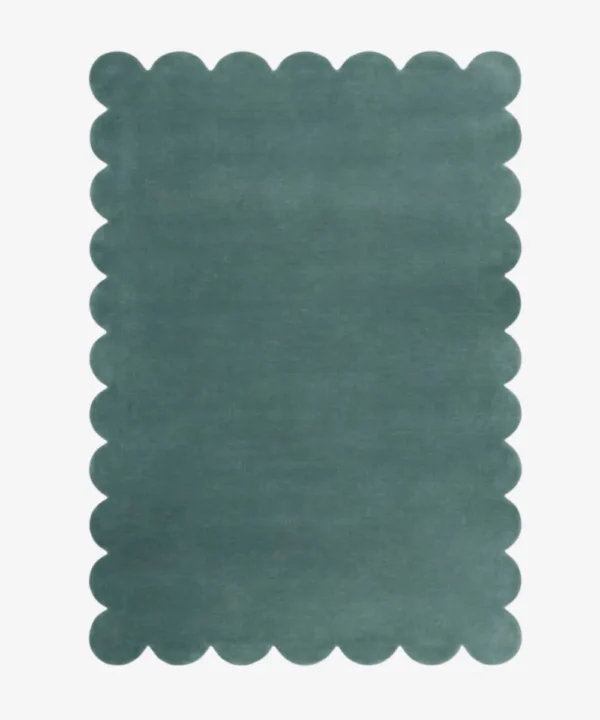 Top down view of the Ocean Mist teal colored hand tufted wool rug on a white background showing the rectangular shape and scalloped edges.