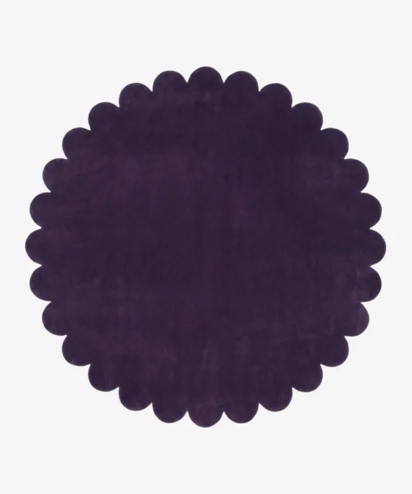 Top down view of the Plum Eclipse circular rug showing the deep violet wool color and scalloped edges.
