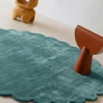 Close up angled shot of the Sagewave rug highlighting the plush teal wool pile and tufted craftsmanship.