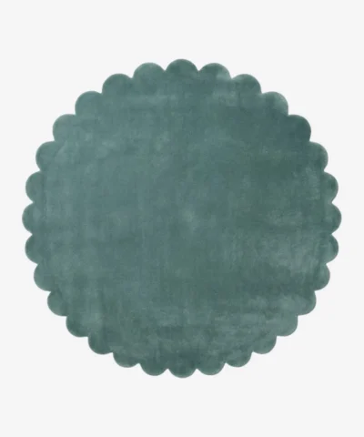 Top down flat lay view of the Sagewave circular rug showing the soft teal green wool color and scalloped border.