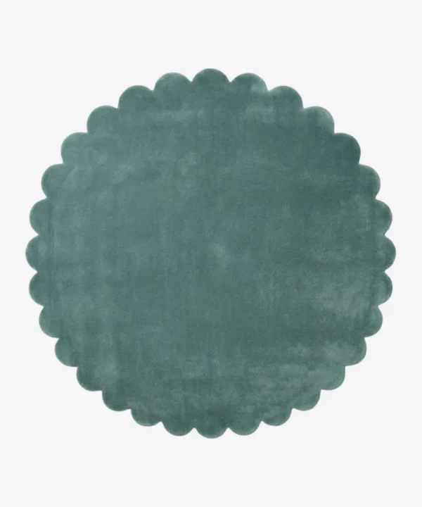Top down flat lay view of the Sagewave circular rug showing the soft teal green wool color and scalloped border.