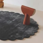 Close up angled shot of the Slate Cloud rug highlighting the plush dark grey wool pile and tufted craftsmanship.