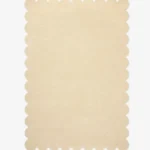 Top down view of the Vanilla Crest cream colored hand tufted wool rug on a white background showing the rectangular shape and scalloped edges.