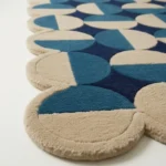 Close up low angle shot of the Coastal Mosaic rug highlighting the dense hand tufted wool texture and the modern half circle design.