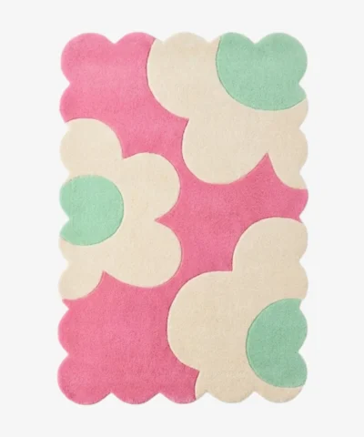 Top down view of the Blush Petalia rug featuring large abstract cream and mint green flower motifs on a vibrant pink wool background with scalloped edges.