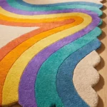 Angled perspective of the Chromatic Wave rug on a wooden floor, displaying the unique wavy borders and the bold colorful design perfect for a modern space.