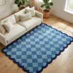High angle view of the Coastal Current rug on a wooden floor, highlighting the plush hand-tufted wool texture and the rhythmic flow of the blue checkerboard design.