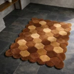 Perspective view of the Cocoa Harlequin rug placed on a dark tiled floor, highlighting the plush hand-tufted wool texture and the rhythmic flow of the geometric design.