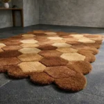 Close-up detail of the Cocoa Harlequin rug, showing the thick hand-tufted pile, precisely carved color blocks, and the high-quality finish of the scalloped edge.