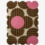 Top down view of the Dusky Bloom rug featuring a bold 1970s inspired floral pattern with brown striped petals and vibrant pink circles on a cream background.