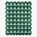 Top down view of the Emerald Steps rug featuring a repeating geometric pattern of light green U-shapes or steps on a deep emerald green wool background, finished with custom scalloped edges.