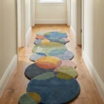 Eye level view of the Eucalyptus Veil runner rug placed in a bright hallway, featuring a soothing geometric design of overlapping circles in eucalyptus green, blue, and terracotta tones.