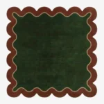 Top down view of the Forest Frame Square rug featuring a lush deep green central field framed by a wavy cream line and a rust-colored scalloped border.
