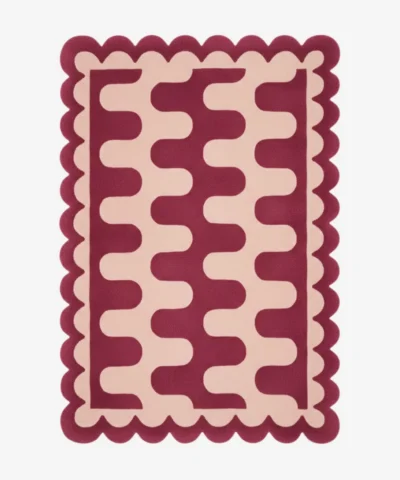 Top down view of the Garnet Loop rug featuring a rich maroon wool background with a bold cream wavy geometric pattern and custom scalloped edges.