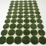 Angled full view of the Still Meadow hand tufted area rug, showcasing the modern retro polka dot design and the unique scalloped shape created by the circle edges.