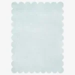Top down flat lay of the Glacier Haze hand tufted rug featuring a calming solid ice blue color and decorative wavy edges isolated on a white background.