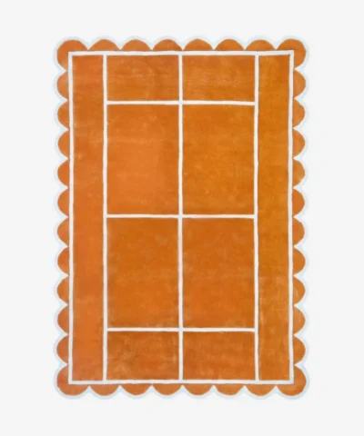 Top down view of the Hearth Grid rug featuring a vibrant terracotta orange wool background with a white geometric line pattern resembling a tennis court layout, finished with playful scalloped edges.