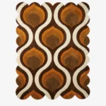 Top down flat lay of the Honeyed Waves rug featuring a retro 70s inspired ogee pattern with wavy layers of brown, amber, orange, and cream wool.