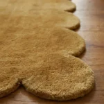 Close-up angled view of the Honeystone runner rug, highlighting the dense, plush hand-tufted New Zealand wool and viscose silk texture and the gracefully contoured mustard yellow scalloped border.