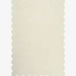 Top down flat lay of the Ivory Drift hand tufted rug featuring a solid off white color and decorative wavy edges isolated on a white background.