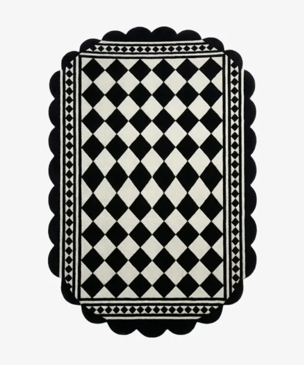 Top down view of the Ivory Lattice rug featuring a classic black and white diamond grid pattern with a geometric border and decorative scalloped edges.