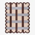 Top down view of the Linen Blend rug featuring a cream wool background with an interlaced grid pattern of dark brown and light grey stripes, framed by a dark brown scalloped border.