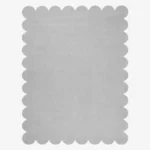 Top down flat lay of the Mistfall hand tufted rug featuring a calming solid silver gray color and decorative wavy edges isolated on a white background.