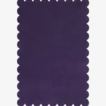 Top down flat lay of the Nightberry rug featuring a rich deep purple color and decorative scalloped borders isolated on a white background.