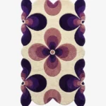 Top down flat lay of the Nocturne Bloom rug featuring a retro geometric floral pattern with dark purple and lilac petals on a cream wool background.