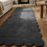 Close-up angled view of the Obsira runner rug, highlighting the dense, plush hand-tufted New Zealand wool and viscose silk texture and the gracefully contoured dark grey scalloped border.