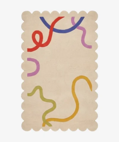 Top down flat lay of the Pastel Doodle rug featuring a soft cream background with playful abstract lines in red blue purple and yellow.