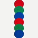 Top-down view of the Pastel Ring Stack runner rug against a white background, featuring a vertical geometric pattern of overlapping circles in bold, repeating shades of red, green, and blue. The intersecting circular shapes naturally form a continuous contoured scalloped outer edge along the plush hand-tufted New Zealand wool and viscose silk runner.