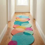 Eye level view of the Pastel Tide runner rug placed in a light-filled hallway, displaying a playful overlapping circle design in teal, pink, and yellow tones.