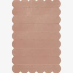 Top down view of the Petal Layers rug featuring a soft dusty pink color with horizontal carved textures and decorative scalloped edges.