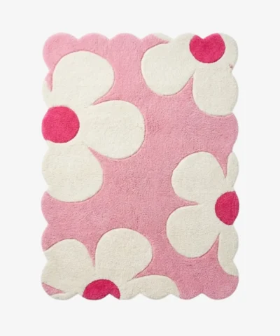 Top down view of the Petal Puff rug featuring a soft pink background with large white cloud like flower shapes and vibrant hot pink centers.