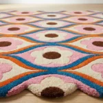 Low angle close up shot of the Petal Weave area rug highlighting the dense plush wool pile and the precise hand carving of the colorful floral motifs.