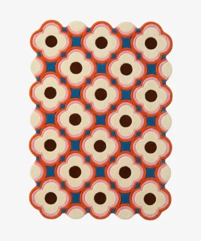 Full view of a modern retro style wool rug with scalloped edges showcasing a colorful blush pink and deep blue flower pattern perfect for adding a pop of color.